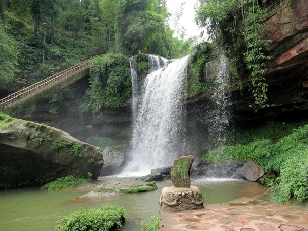Forest waterfall representing protected mountain habitat west of Chengdu