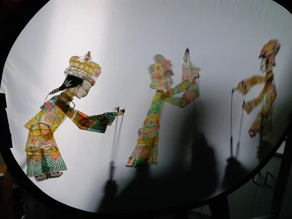 Chinese shadow puppets arranged for performance behind a screen