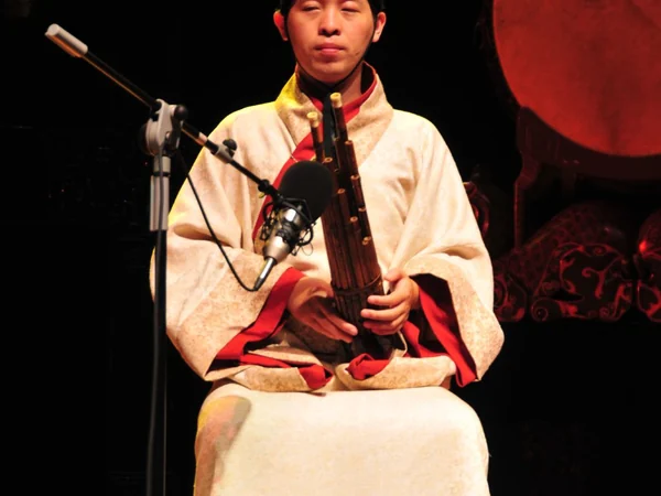 A musician performing on a traditional Chinese wind instrument at Henan Museum A musician performing on a traditional Chinese wind instrument at Henan Museum