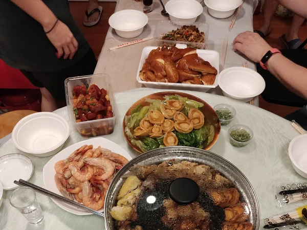 A round table set with shared dishes for a Chinese reunion dinner A round table set with shared dishes for a Chinese reunion dinner