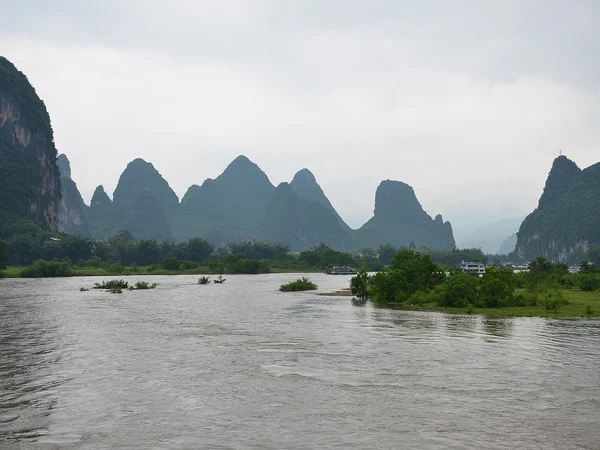 Sightseeing boats moving through the Li River karst landscape in Guilin
