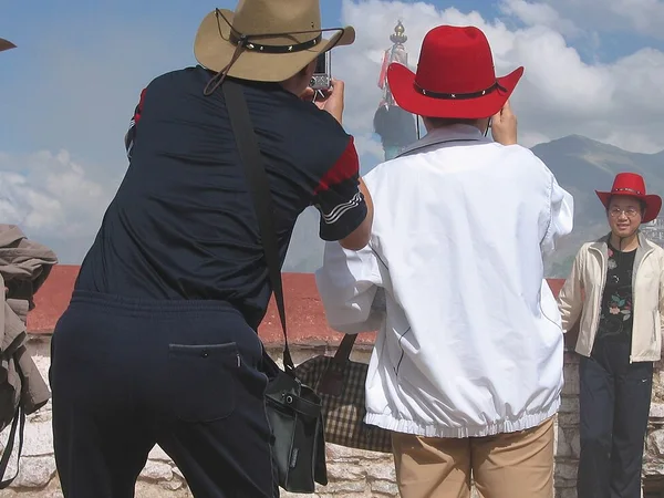 International visitors looking across Lhasa from the roof of Jokhang Temple