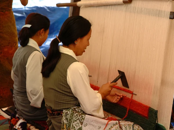 Tibetan textile artisans demonstrating traditional weaving