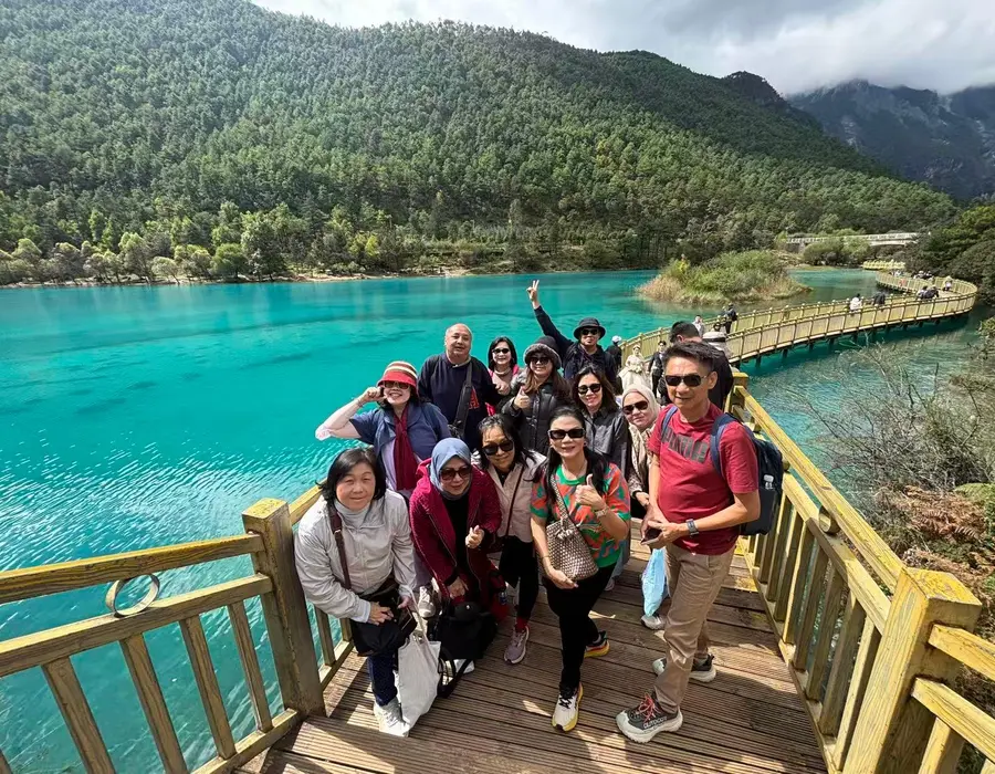 International YUNSKY group beside a turquoise lake in Jiuzhaigou