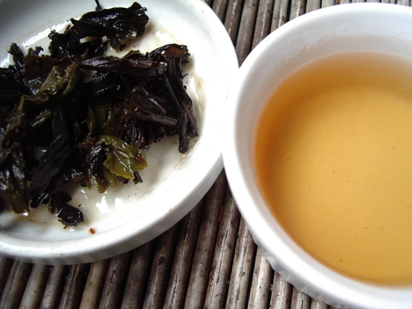Rolled Tieguanyin oolong leaves opening after infusion