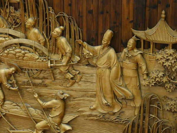 Intricate Chinese wood-carved figures and architecture panel