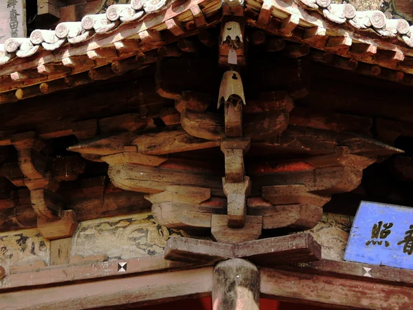 Interlocking dougong brackets beneath the eaves of a timber building Interlocking dougong brackets beneath the eaves of a timber building