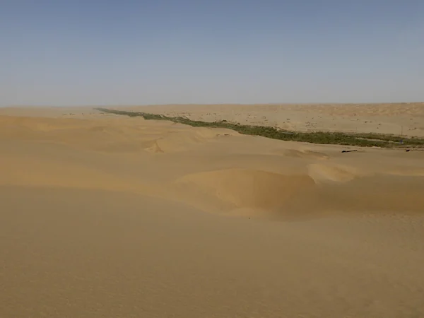 Long highway crossing the Taklamakan Desert in Xinjiang Long highway crossing the Taklamakan Desert in Xinjiang