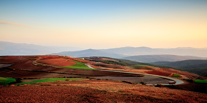 Patchwork crops and exposed red soil across Dongchuan mountain fields Patchwork crops and exposed red soil across Dongchuan mountain fields