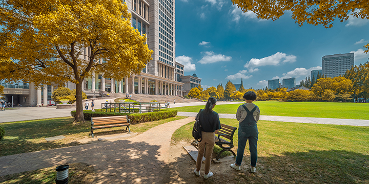 Students walking across a modern Fudan University campus in Shanghai