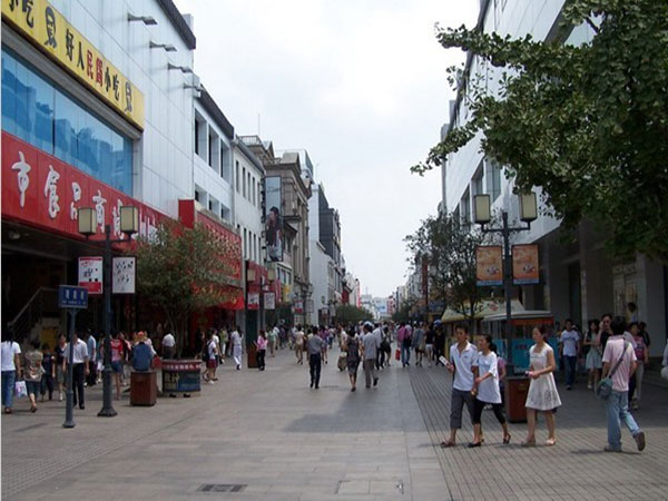Pedestrians and storefronts along Guanqian Street in central Suzhou