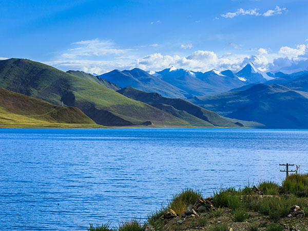 Blue alpine lake beneath snowy peaks in Tibet during summer Blue alpine lake beneath snowy peaks in Tibet during summer
