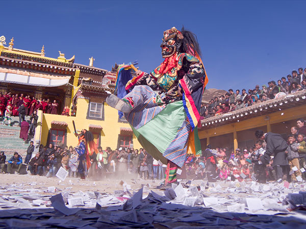 Masked dancer performing at an outdoor Tibetan Bon religious festival