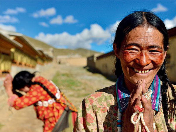 Tibetan pilgrim making prostrations near a monastery on the plateau Tibetan pilgrim making prostrations near a monastery on the plateau